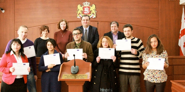 Legal Education for Journalist course graduates hold their graduation certificates. In the back — the speakers, including Justice Renate Winter, TL of the HD-led CJR project (2nd from left). 